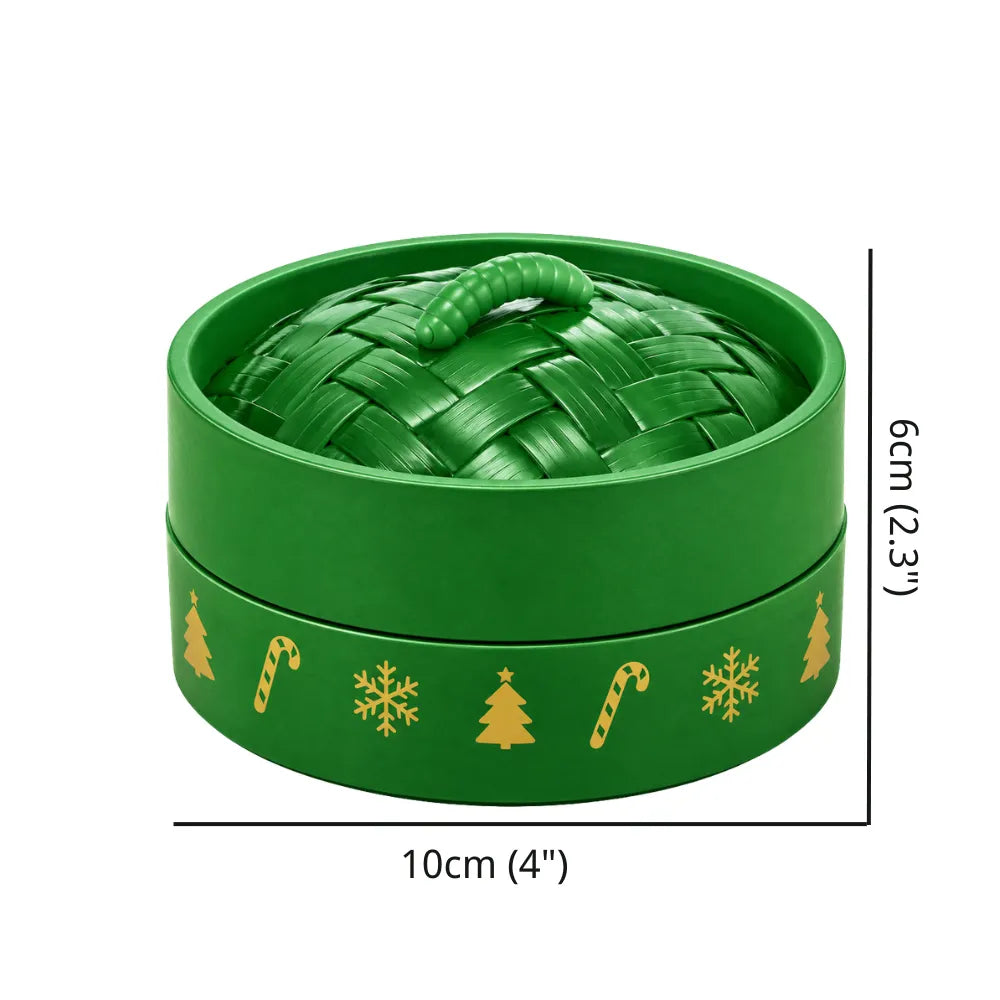 Round green blind box shaped like a dumpling steamer with gold Christmas patterns like trees and candy canes. Includes a woven-textured lid with a handle. Measures 10cm by 6cm. Unique packaging for a Christmas mystery glitter dumpling squishy.