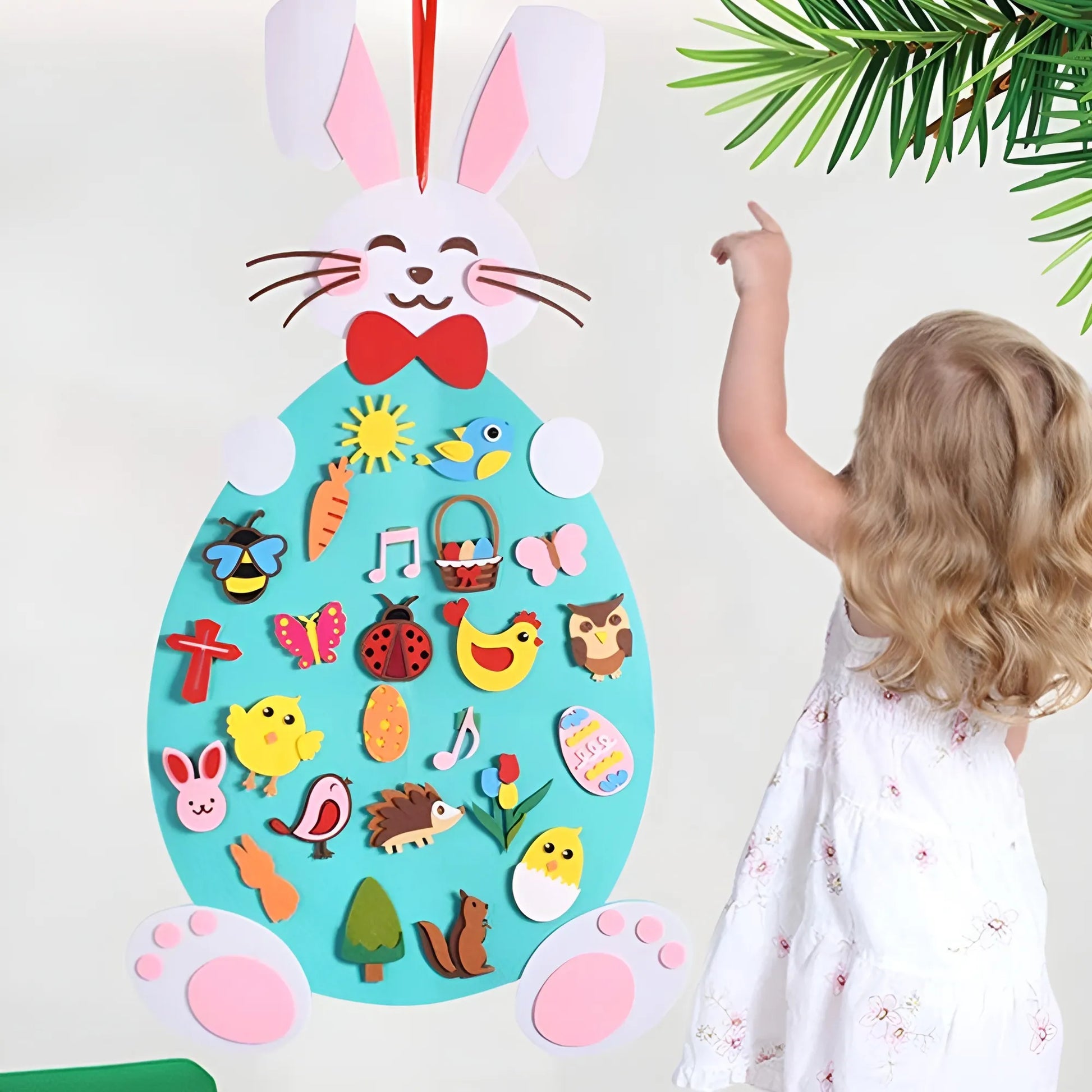 Child interacting with a colorful Easter-themed felt board with various decorations.