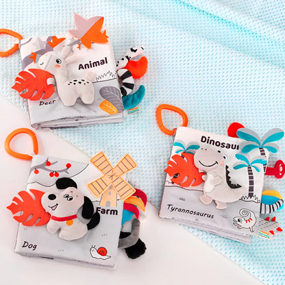 Three educational baby books with plush toys on a light blue blanket