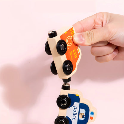Hand holding a magnetic toy police car with a pink background