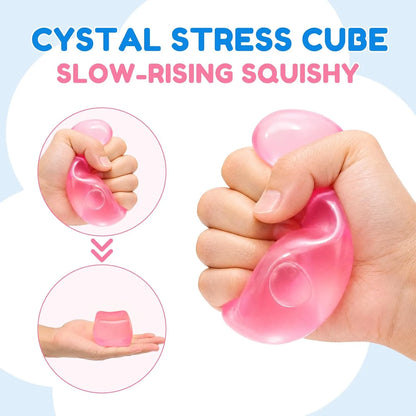 Pink slow-rising stress cube being squeezed by hand to show its translucent, soft texture ideal for sensory play and anxiety relief.