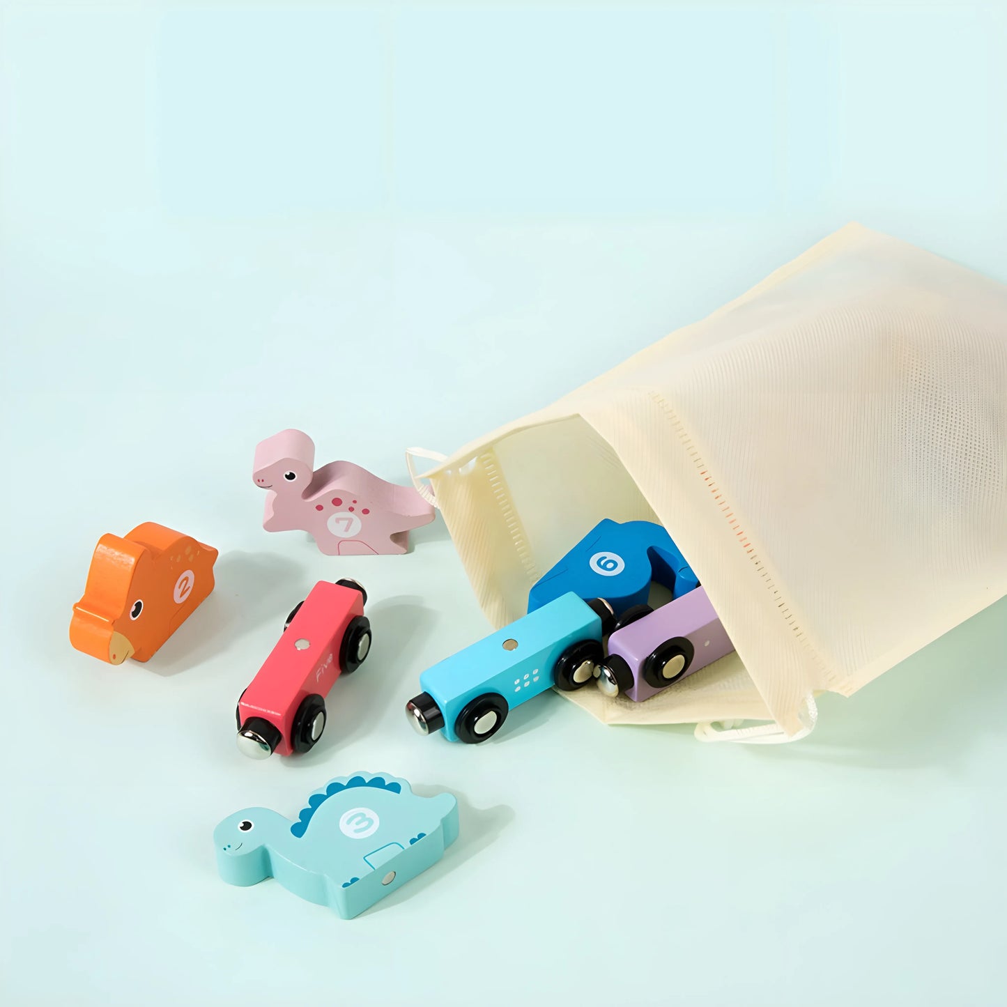 Set of magnetic toy trains and dinosaurs with a drawstring bag on a light blue background