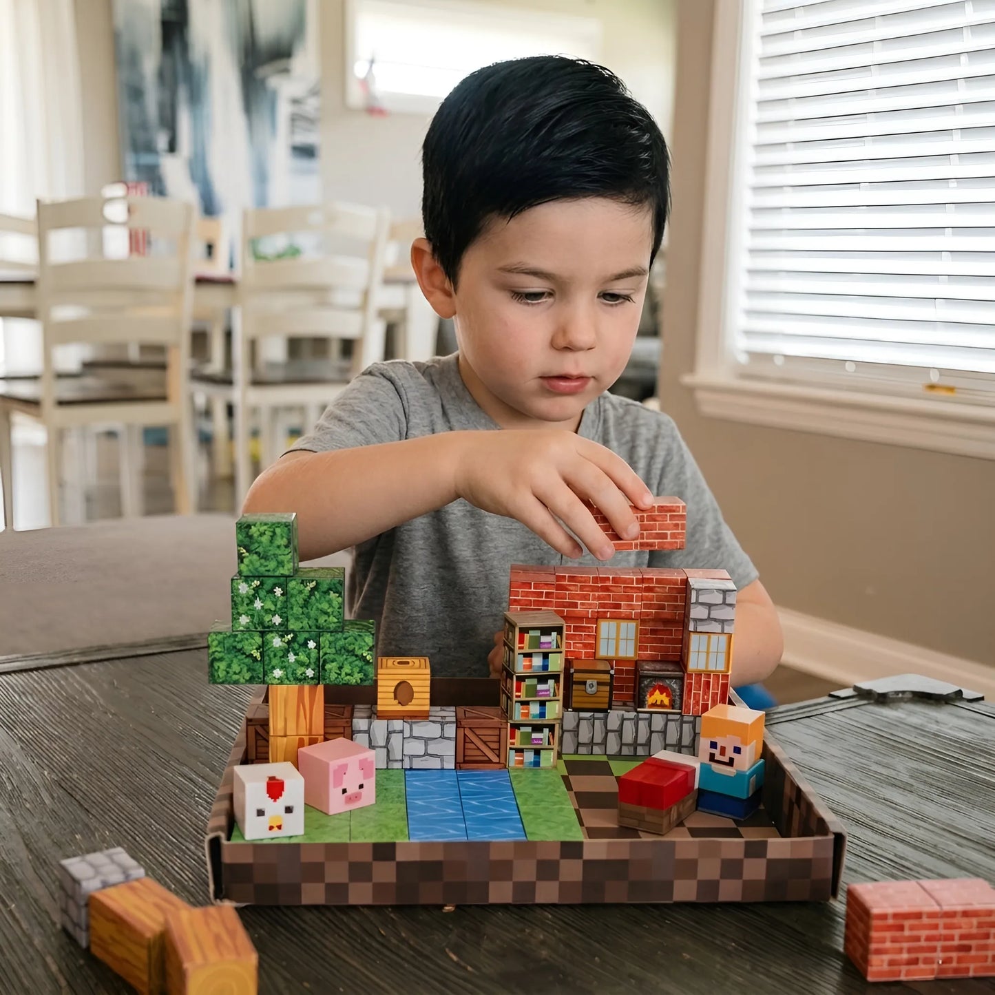 Child playing with a Minecraft-themed building set on a table.