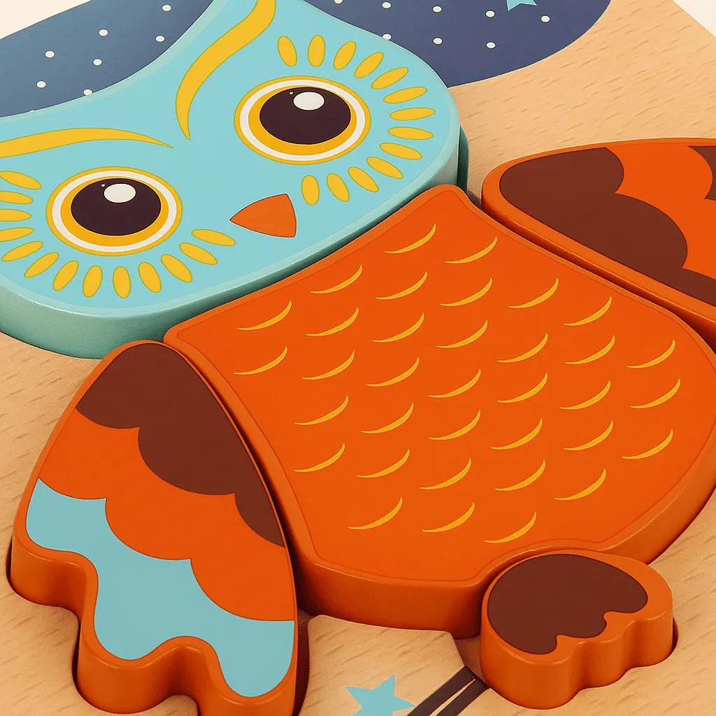 Two owl-shaped cookie cutters on a wooden surface